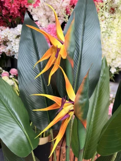 تصویر نزدیک از برگ‌های ژله‌ای و چهار تنه مقاوم درختچه مصنوعی پرنده بهشتی ۱۳۰ سانتی‌متری.