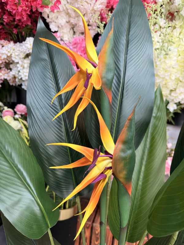 تصویر نزدیک از برگ‌های ژله‌ای و چهار تنه مقاوم درختچه مصنوعی پرنده بهشتی ۱۳۰ سانتی‌متری.