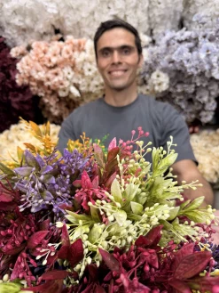 بوته مصنوعی رنگ صورتی در گلدانی روی میز بالکن، نشان‌دهنده مقاومت در برابر نور خورشید