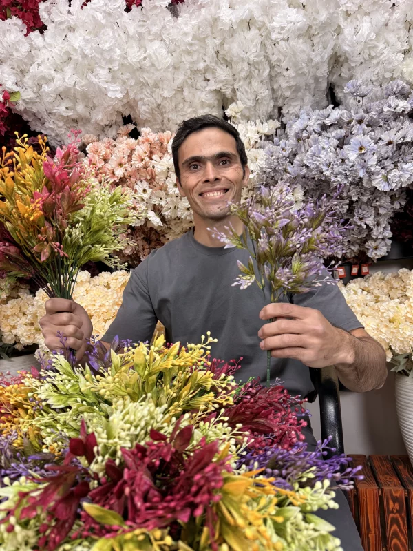 چیدمان چند بوته مصنوعی با رنگ‌های مختلف در یک فلاورباکس چوبی برای دکوراسیون داخلی