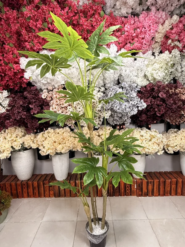 تصویر نزدیک از برگ‌های لمسی درختچه آرالیا مصنوعی، با نمایش رگ‌برگ‌های زرد و جزئیات دقیق و طبیعی.